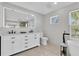 Bright bathroom featuring double vanity, large mirror, soaking tub, and natural light from large window at 19 Crescent S Pl, St Petersburg, FL 33711