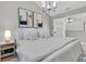Comfortable bedroom features neutral tones, artwork, white bedding, bedside table and stylish chandelier at 19 Crescent S Pl, St Petersburg, FL 33711