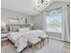 Neutral bedroom boasts large window, soft lighting, and decorative mirrors above bedside tables at 19 Crescent S Pl, St Petersburg, FL 33711