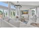 Bright living room with floor-to-ceiling windows, a modern chandelier, and white furniture at 19 Crescent S Pl, St Petersburg, FL 33711