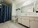 Bathroom featuring a single sink vanity, shower with blue curtain and accessible toilet at 203 Rickenbacker Dr, Sun City Center, FL 33573