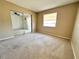 A carpeted bedroom featuring a window and sliding mirror door at 203 Rickenbacker Dr, Sun City Center, FL 33573