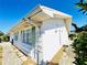 Bright, white exterior showcasing the side of the home, green shutters, and a pathway at 203 Rickenbacker Dr, Sun City Center, FL 33573