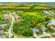 Overhead view of a home nestled amongst trees and a nature preserve, surrounded by a community with well-manicured lawns at 211 Royal Bonnet Dr, Apollo Beach, FL 33572