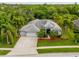 Stunning aerial view of a charming home with mature palm trees, lush landscaping, and a spacious driveway at 211 Royal Bonnet Dr, Apollo Beach, FL 33572