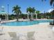 Resort-style community pool featuring lounge chairs, tables, shady gazebos and lush palm trees on a sunny day at 211 Royal Bonnet Dr, Apollo Beach, FL 33572