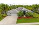 Beautiful single-story home boasts a gray tile roof, mature palms, and a spacious three-car garage at 211 Royal Bonnet Dr, Apollo Beach, FL 33572