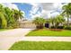 Inviting home exterior with a well-manicured lawn, mature landscaping, and a spacious three car driveway at 211 Royal Bonnet Dr, Apollo Beach, FL 33572