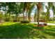 Well-manicured front yard with mature trees, lush green grass, and a charming home, perfect for curb appeal at 211 Royal Bonnet Dr, Apollo Beach, FL 33572