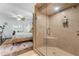 Bathroom view featuring a glass-door shower and bedroom with wood-framed bed in the background at 25 Harbor Oaks Cir, Safety Harbor, FL 34695