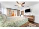 Modern bedroom with a wooden bed, ceiling fan, flat-screen TV, and sliding barn door access at 25 Harbor Oaks Cir, Safety Harbor, FL 34695
