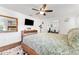 Relaxing bedroom with a queen bed, ceiling fan, dresser, and an open doorway to another room at 25 Harbor Oaks Cir, Safety Harbor, FL 34695