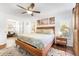 Bright bedroom featuring a wooden bed frame, ceiling fan, and beach-themed wall art at 25 Harbor Oaks Cir, Safety Harbor, FL 34695
