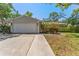Single-story home with two-car garage, landscaping, and long walkway to the front door at 25 Harbor Oaks Cir, Safety Harbor, FL 34695