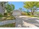 Single-story home with a two-car garage, landscaping, and long driveway at 25 Harbor Oaks Cir, Safety Harbor, FL 34695