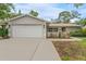 Traditional home featuring an attached two car garage and decorative shrubbery in the front yard at 25 Harbor Oaks Cir, Safety Harbor, FL 34695