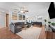 Bright and airy living room with a large gray sectional, stylish decor, and a view into the dining area at 25 Harbor Oaks Cir, Safety Harbor, FL 34695