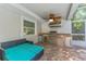 Well-equipped outdoor kitchen with stainless steel appliances, sink, ceiling fan and cozy daybed at 25 Harbor Oaks Cir, Safety Harbor, FL 34695
