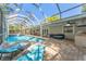 Inviting screened-in pool area with comfortable lounge chairs and an outdoor dining area at 25 Harbor Oaks Cir, Safety Harbor, FL 34695