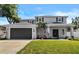 Charming two-story home featuring a manicured lawn, a two-car garage, and tasteful landscaping at 3612 W Pearl Ave, Tampa, FL 33611