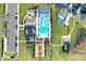 An aerial view showcasing a community clubhouse, pool, playground, and parking lot with lush green surroundings at 36454 Flats St, Zephyrhills, FL 33541