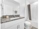Bright bathroom with a granite countertop vanity, white cabinets, and shower with gray curtain at 36454 Flats St, Zephyrhills, FL 33541