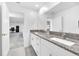 Bathroom with a double vanity, granite countertops, and adjacent doorway at 36454 Flats St, Zephyrhills, FL 33541