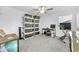 Bedroom with ceiling fan, storage shelves, workstation, and exercise bike at 36454 Flats St, Zephyrhills, FL 33541