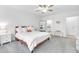 Bright bedroom featuring neutral walls and carpet, a ceiling fan, a queen bed, and a door to the en-suite bathroom at 36454 Flats St, Zephyrhills, FL 33541