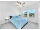 Comfortable bedroom featuring a blue bedspread, two windows with blinds, and a bedside table with a lamp at 36454 Flats St, Zephyrhills, FL 33541