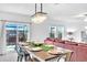 The dining area has a chandelier and dining table leading into a living room and an outdoor patio area at 36454 Flats St, Zephyrhills, FL 33541