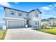Charming two-story home features a well-maintained lawn, landscaping, and a spacious driveway leading to the garage at 36454 Flats St, Zephyrhills, FL 33541