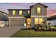 Beautiful two-story home featuring a well-manicured lawn, colorful landscaping, a two-car garage, and decorative exterior shutters at 36454 Flats St, Zephyrhills, FL 33541