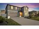 Two-story home exhibiting a well-manicured lawn, expansive driveway, and gray facade at 36454 Flats St, Zephyrhills, FL 33541