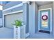 Close-up of the front entrance featuring a wreath on the door, stylish planter, and views of the attached two-car garage at 36454 Flats St, Zephyrhills, FL 33541