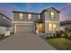 Charming two-story home with a well-manicured lawn, gray exterior, and a two-car garage at 36454 Flats St, Zephyrhills, FL 33541