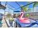 Fun screened-in patio features flamingo hot tub, dining set, and lush landscaping at 36454 Flats St, Zephyrhills, FL 33541