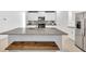 Modern kitchen features white cabinets, stainless steel appliances, granite countertops, and a wooden bench at 36454 Flats St, Zephyrhills, FL 33541