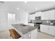 Bright and airy kitchen featuring white cabinets, a granite island with seating, and stainless steel appliances at 36454 Flats St, Zephyrhills, FL 33541