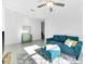 Comfortable living room with a teal sofa, plush rug, and bright, natural light at 36454 Flats St, Zephyrhills, FL 33541
