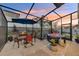 Screened in patio with a grill, dining table, hot tub, and landscaped backyard at 36454 Flats St, Zephyrhills, FL 33541