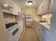 Compact kitchen with white appliances, neutral tile backsplash, and tile floors at 379 47Th N Ave # 104, St Petersburg, FL 33703