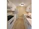 Compact kitchen with white appliances, neutral tile backsplash, and tile floors at 379 47Th N Ave # 104, St Petersburg, FL 33703