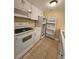 Cozy kitchen featuring white appliances, ample cabinetry, and tile flooring at 379 47Th N Ave # 104, St Petersburg, FL 33703