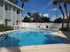 A bright blue pool is bordered by palm trees and a white fence at 379 47Th N Ave # 104, St Petersburg, FL 33703