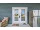 Cozy balcony featuring a wicker chair, 'Hello' doormat, stainless steel refrigerator, and a view of the waterway at 4039 Casa Ct, Hernando Beach, FL 34607