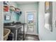 Modern laundry room with front-loading washer and dryer, plus extra shelves and access to the outside at 4039 Casa Ct, Hernando Beach, FL 34607