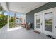 Inviting porch with seating area, white railing, and views of the neighborhood beyond the double glass doors at 4039 Casa Ct, Hernando Beach, FL 34607