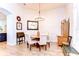 Charming dining area featuring a round wood table, upholstered chairs, and elegant lighting fixtures at 5114 Whispering Leaf Trl, Valrico, FL 33596