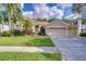 Charming single-story home boasts a lush front lawn, landscaping, and a two-car garage at 5114 Whispering Leaf Trl, Valrico, FL 33596